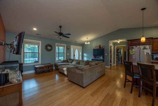 living room featuring ceiling fan, light wood finished floors, baseboards, lofted ceiling, and visible vents