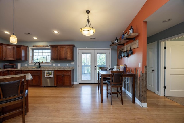 kitchen featuring a sink, visible vents, light wood-style floors, and dishwasher