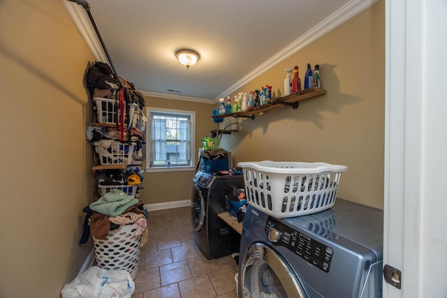laundry area with stone finish floor, laundry area, baseboards, ornamental molding, and washer and dryer