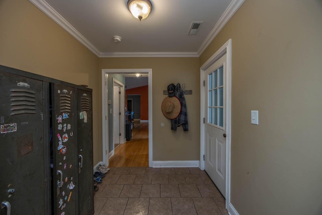 corridor with crown molding, baseboards, and tile patterned flooring