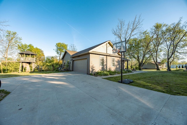 view of side of property featuring a lawn, an attached garage, and driveway