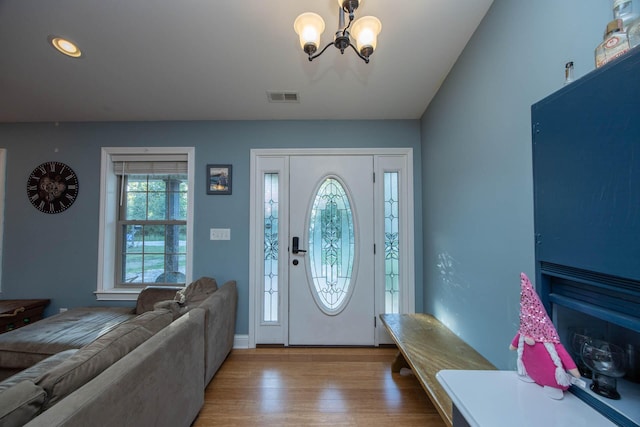 entryway with wood finished floors, a chandelier, and visible vents