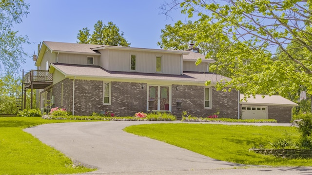 traditional-style home featuring brick siding, a balcony, and a front lawn