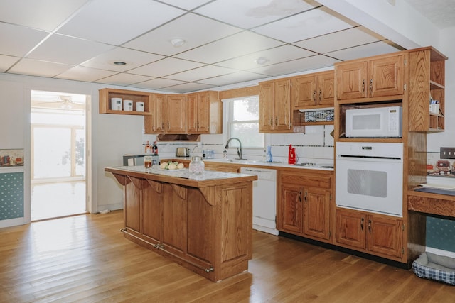 kitchen with white appliances, open shelves, light wood-style floors, and light countertops