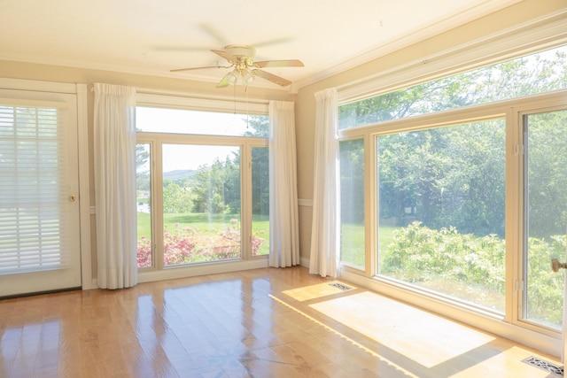 unfurnished sunroom with crown molding, wood finished floors, and visible vents
