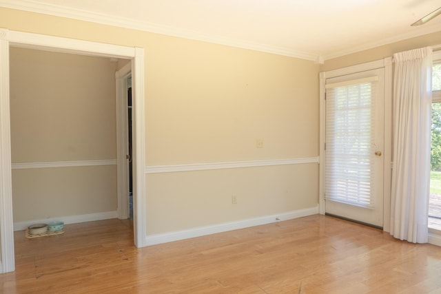 empty room featuring baseboards, ornamental molding, and wood finished floors