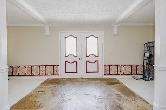 carpeted entrance foyer with ornamental molding, a textured ceiling, and beam ceiling