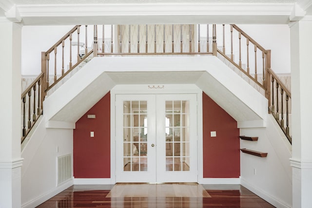stairway featuring baseboards, wood finished floors, visible vents, and french doors