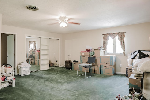 interior space with carpet floors, ceiling fan, and visible vents