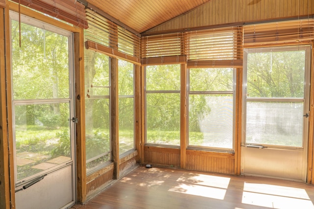 unfurnished sunroom with a wealth of natural light, wood finished floors, and lofted ceiling