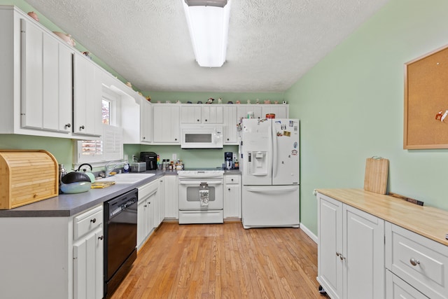 kitchen featuring a sink, a textured ceiling, white cabinets, and white appliances