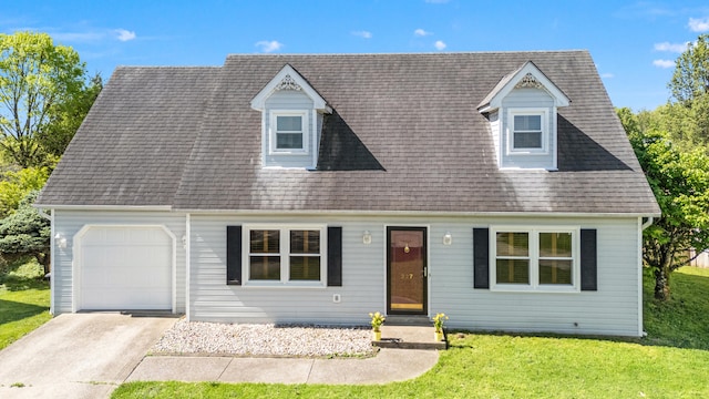 new england style home with a garage, a shingled roof, concrete driveway, and a front lawn