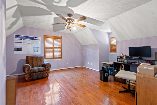 office space with a ceiling fan, a wealth of natural light, lofted ceiling, and hardwood / wood-style floors