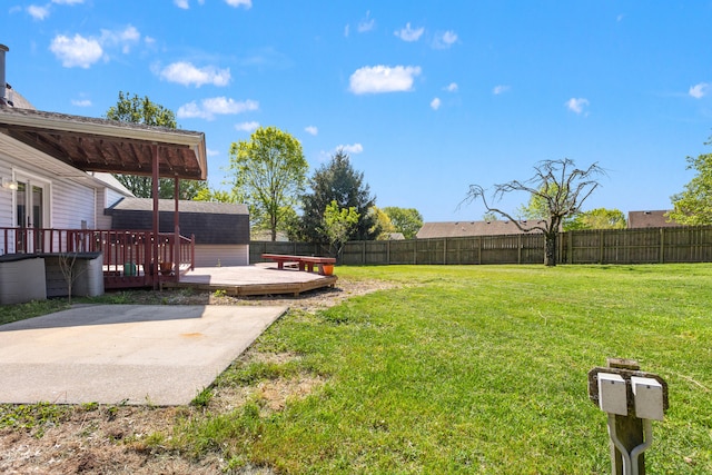 view of yard with a patio, a fenced backyard, and a deck
