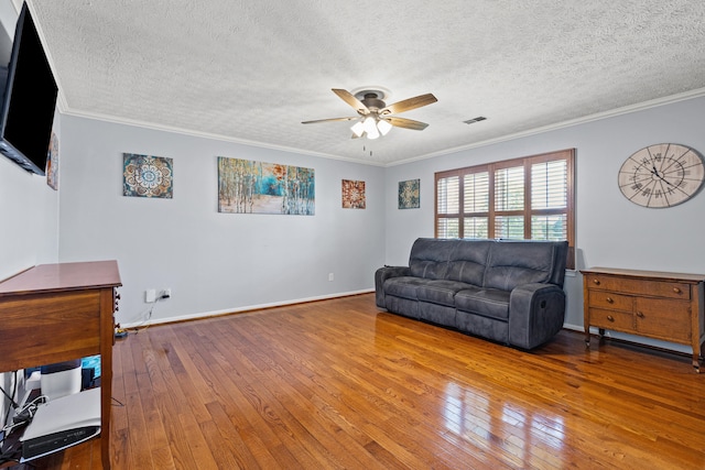 living room featuring a ceiling fan, a textured ceiling, visible vents, crown molding, and hardwood / wood-style floors