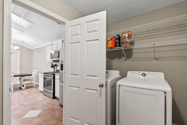 washroom with laundry area, light tile patterned flooring, independent washer and dryer, and a chandelier