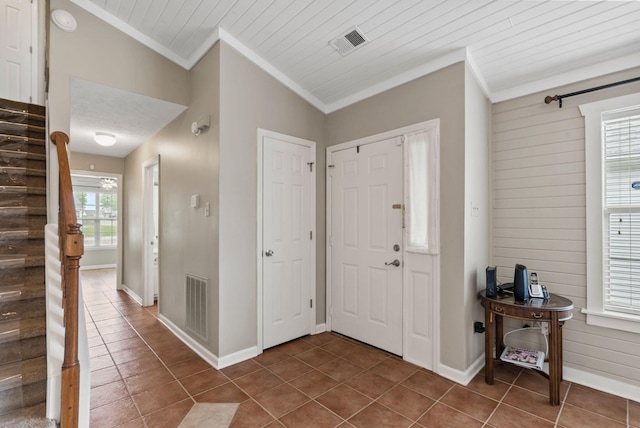 entrance foyer with crown molding, stairs, and visible vents