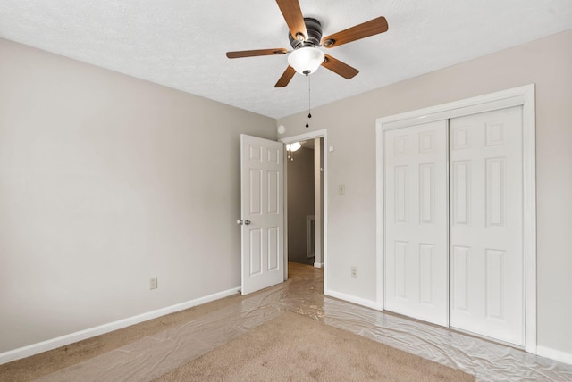 unfurnished bedroom with a ceiling fan, baseboards, light colored carpet, and a closet