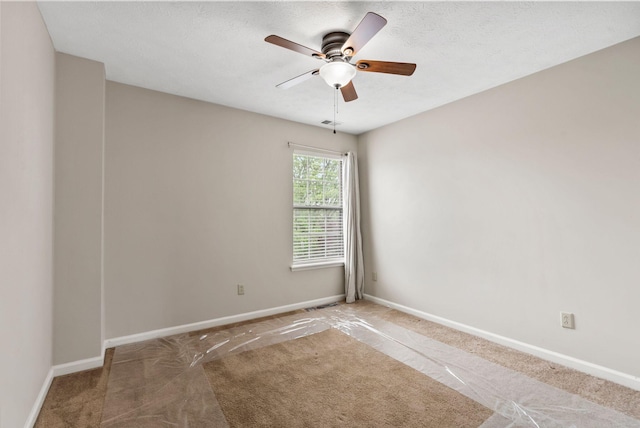 unfurnished room with ceiling fan, visible vents, baseboards, and carpet