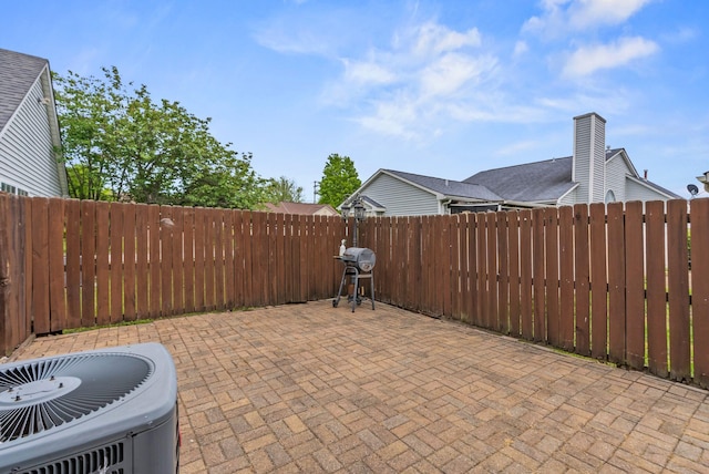 view of patio / terrace with grilling area, cooling unit, and a fenced backyard
