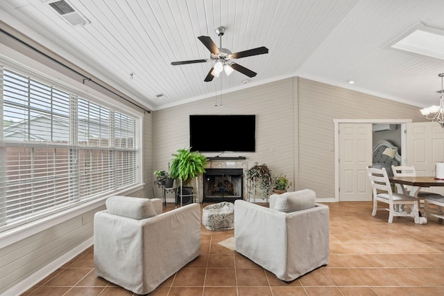 living room with visible vents, a fireplace, vaulted ceiling, ceiling fan with notable chandelier, and light tile patterned flooring