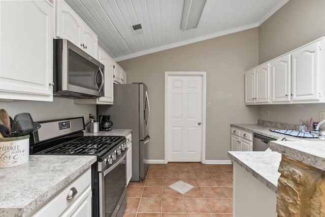 kitchen featuring crown molding, light countertops, white cabinetry, appliances with stainless steel finishes, and vaulted ceiling