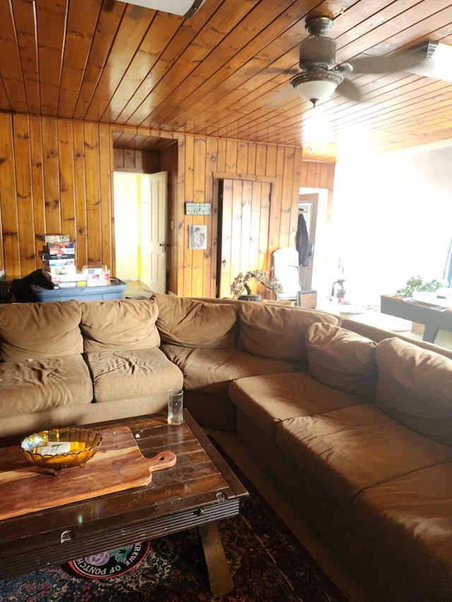 living room featuring wooden walls, wood ceiling, and a ceiling fan