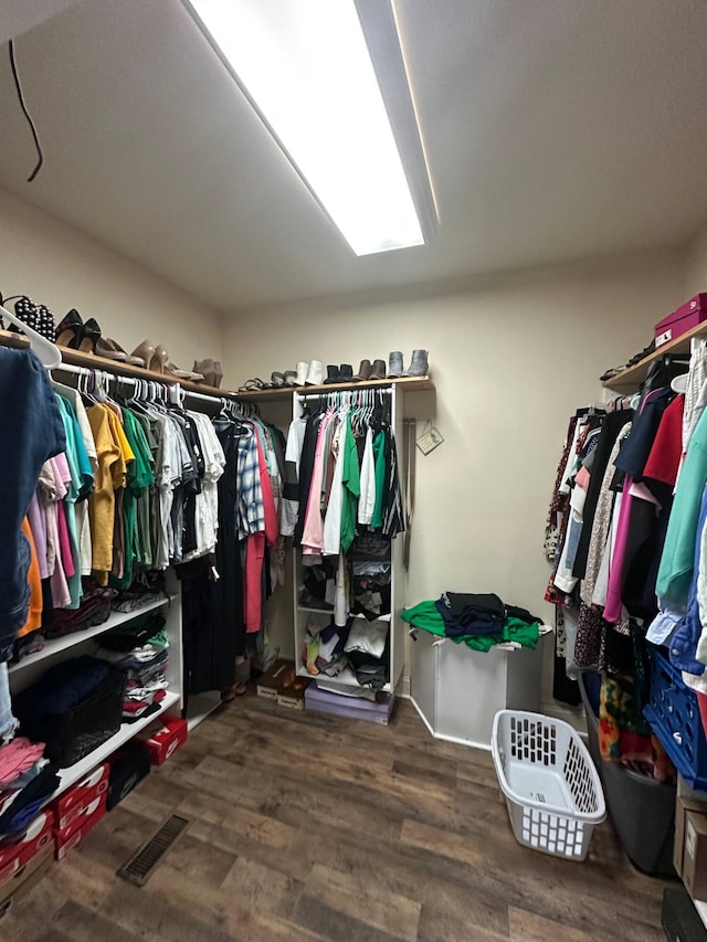 walk in closet with wood finished floors