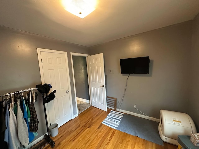 bedroom featuring baseboards and light wood finished floors