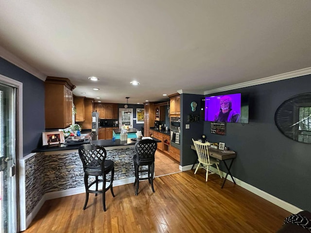 kitchen with a peninsula, dark countertops, baseboards, recessed lighting, and appliances with stainless steel finishes