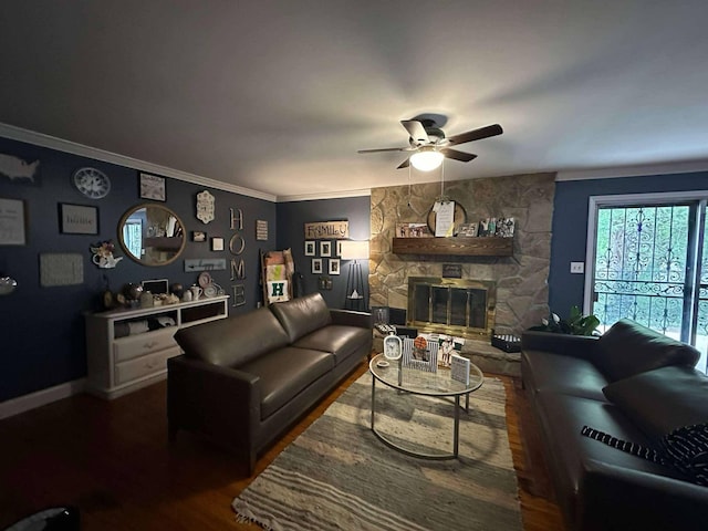 living room featuring ornamental molding, wood finished floors, a fireplace, baseboards, and a ceiling fan