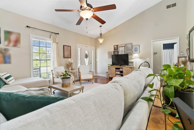 living area featuring ceiling fan, visible vents, wood finished floors, high vaulted ceiling, and baseboards