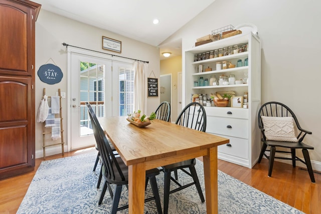 dining space with french doors, recessed lighting, vaulted ceiling, and light wood finished floors