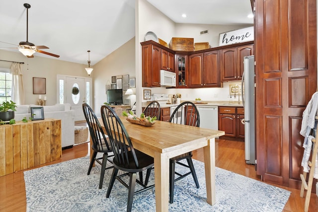 dining room featuring ceiling fan, visible vents, high vaulted ceiling, and light wood-type flooring