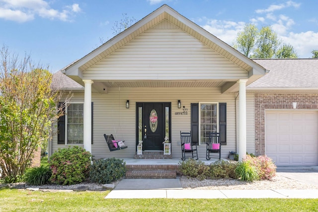 view of front of property featuring a garage, covered porch, and a shingled roof