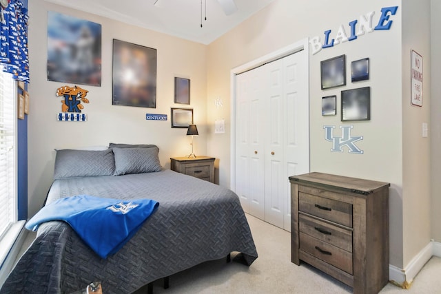 bedroom with a closet, a ceiling fan, and light carpet