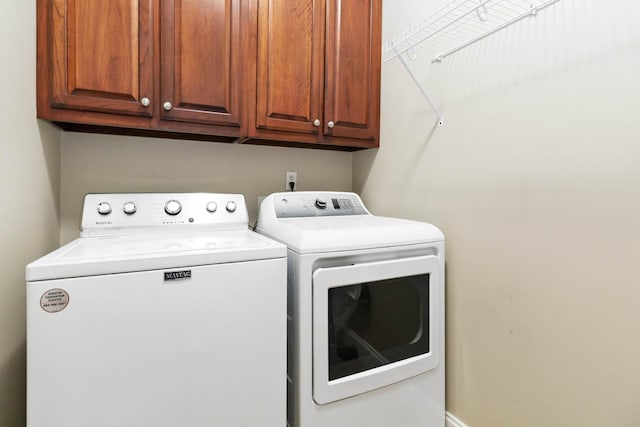 clothes washing area with cabinet space and washer and clothes dryer