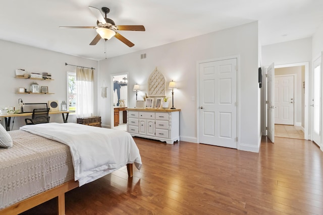 bedroom with baseboards, ceiling fan, hardwood / wood-style flooring, and visible vents