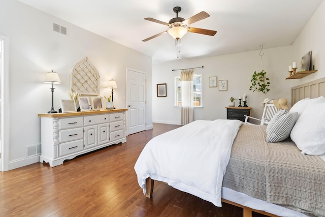 bedroom with ceiling fan, baseboards, visible vents, and wood finished floors