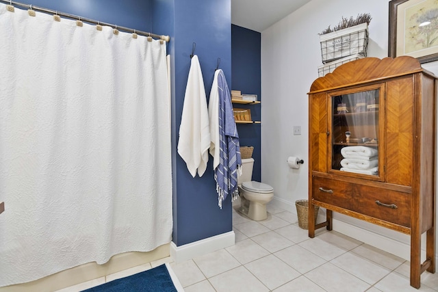 full bath with tile patterned floors, baseboards, toilet, and curtained shower