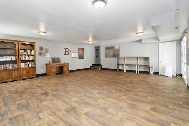 basement featuring baseboards, visible vents, and wood finished floors