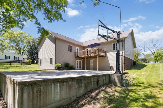 rear view of property with a lawn, cooling unit, and a deck