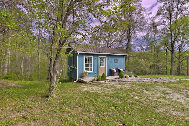 view of outbuilding featuring a forest view and an outdoor structure