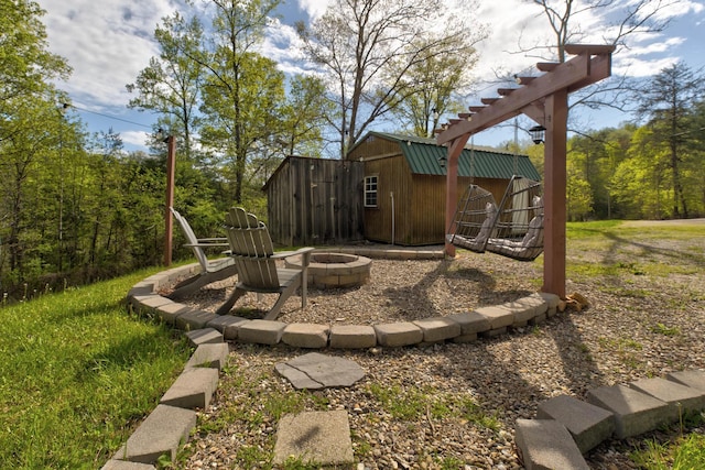 view of yard with a storage shed, an outdoor fire pit, and an outbuilding