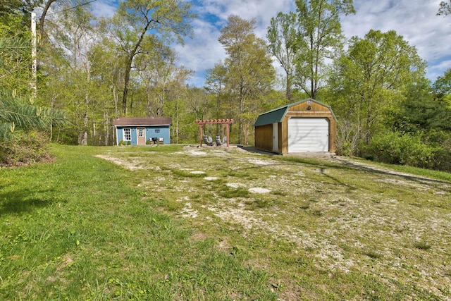 view of yard with a garage and an outbuilding