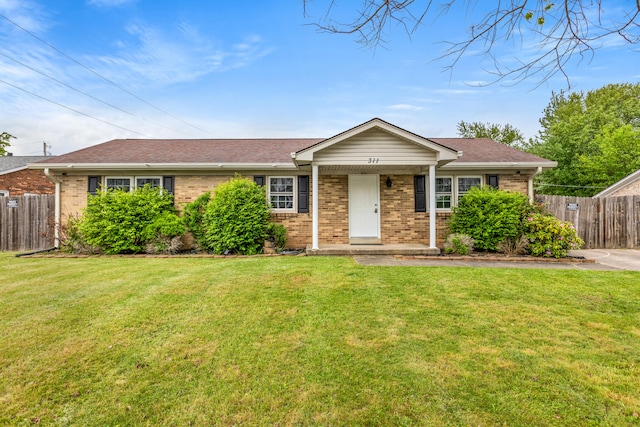 ranch-style home with brick siding, fence, and a front yard