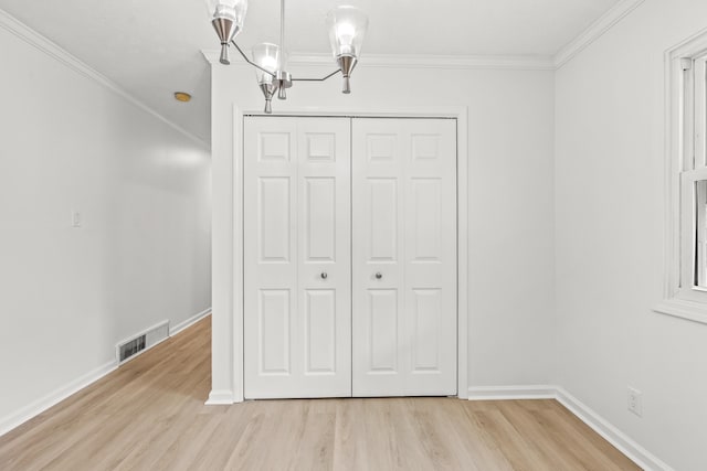 unfurnished dining area with baseboards, ornamental molding, light wood-type flooring, and visible vents