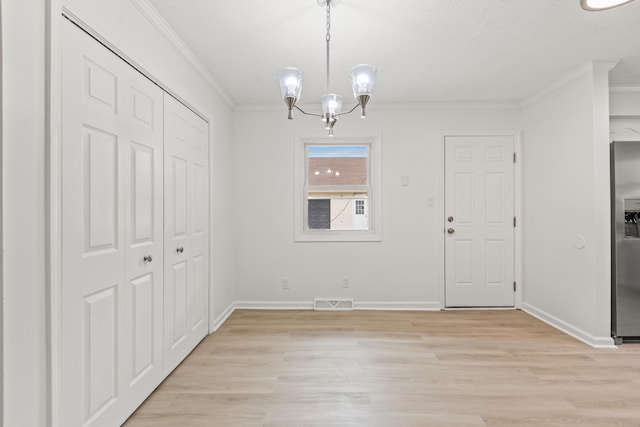 unfurnished dining area featuring crown molding, a notable chandelier, and light wood-type flooring