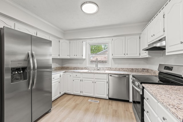 kitchen featuring visible vents, crown molding, appliances with stainless steel finishes, a sink, and under cabinet range hood