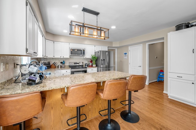 4805 Laurel Creek Cir, Lexington, KY 40515 - kitchen featuring appliances with stainless steel finishes, a peninsula, light stone counters, white cabinetry, and decorative backsplash